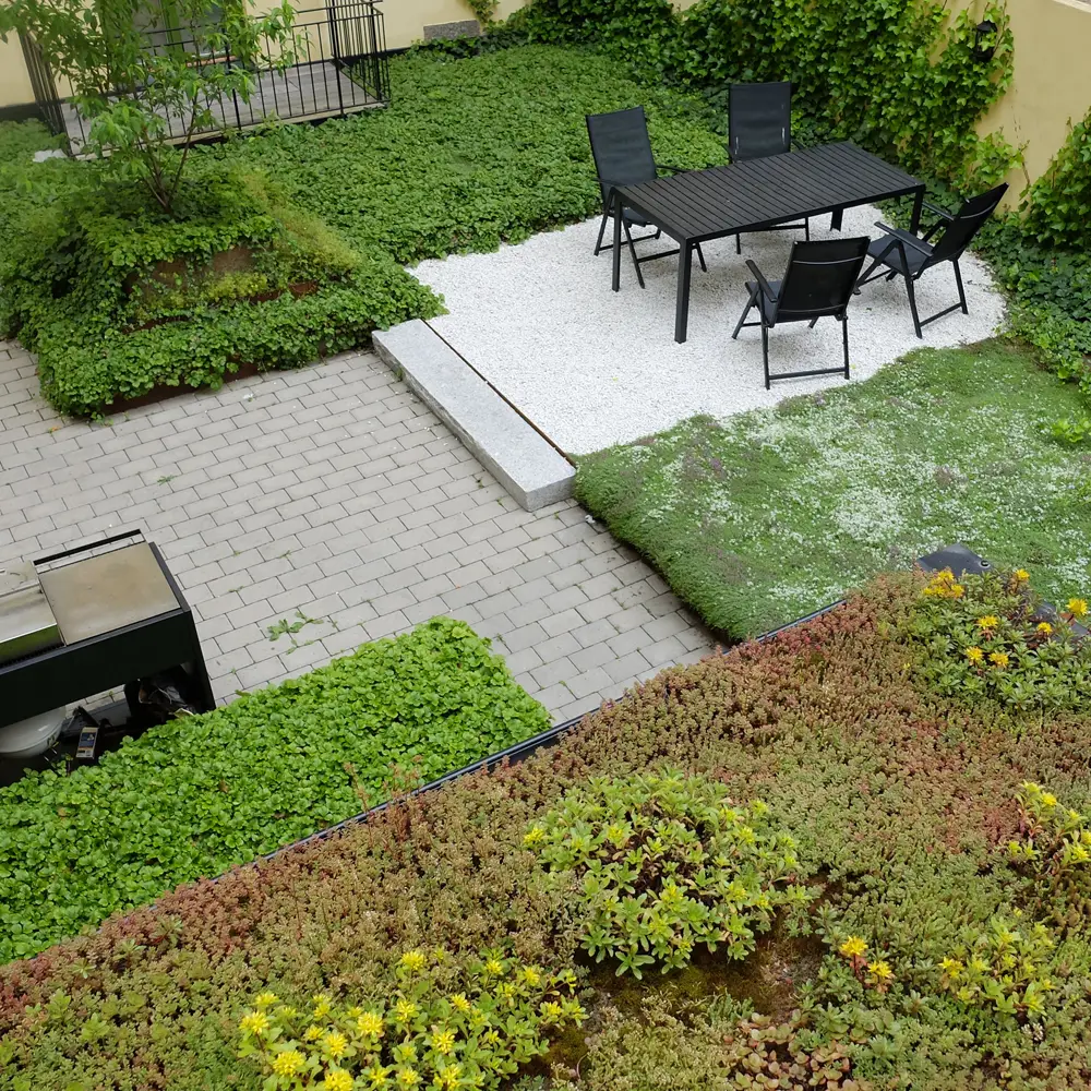 En grønnskende inngård med vakre planting og møblering